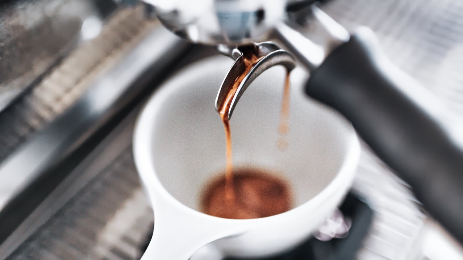 Espresso machine pouring a double espresso into a white cup