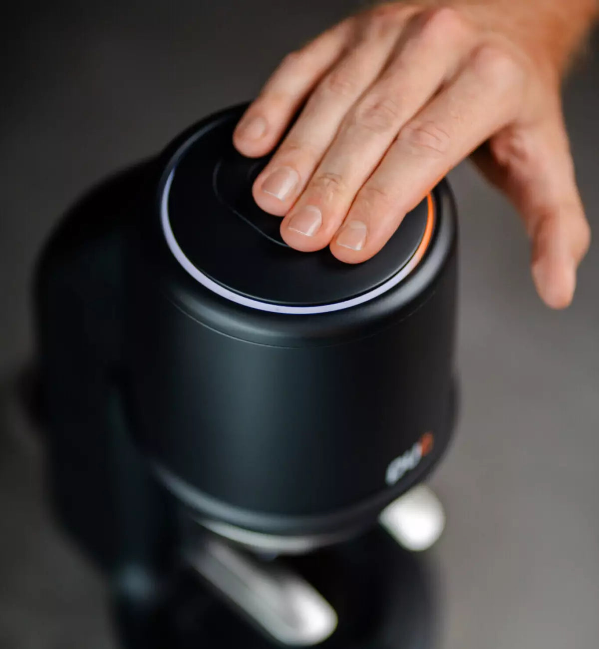 Hand resting on a black PUQ Press