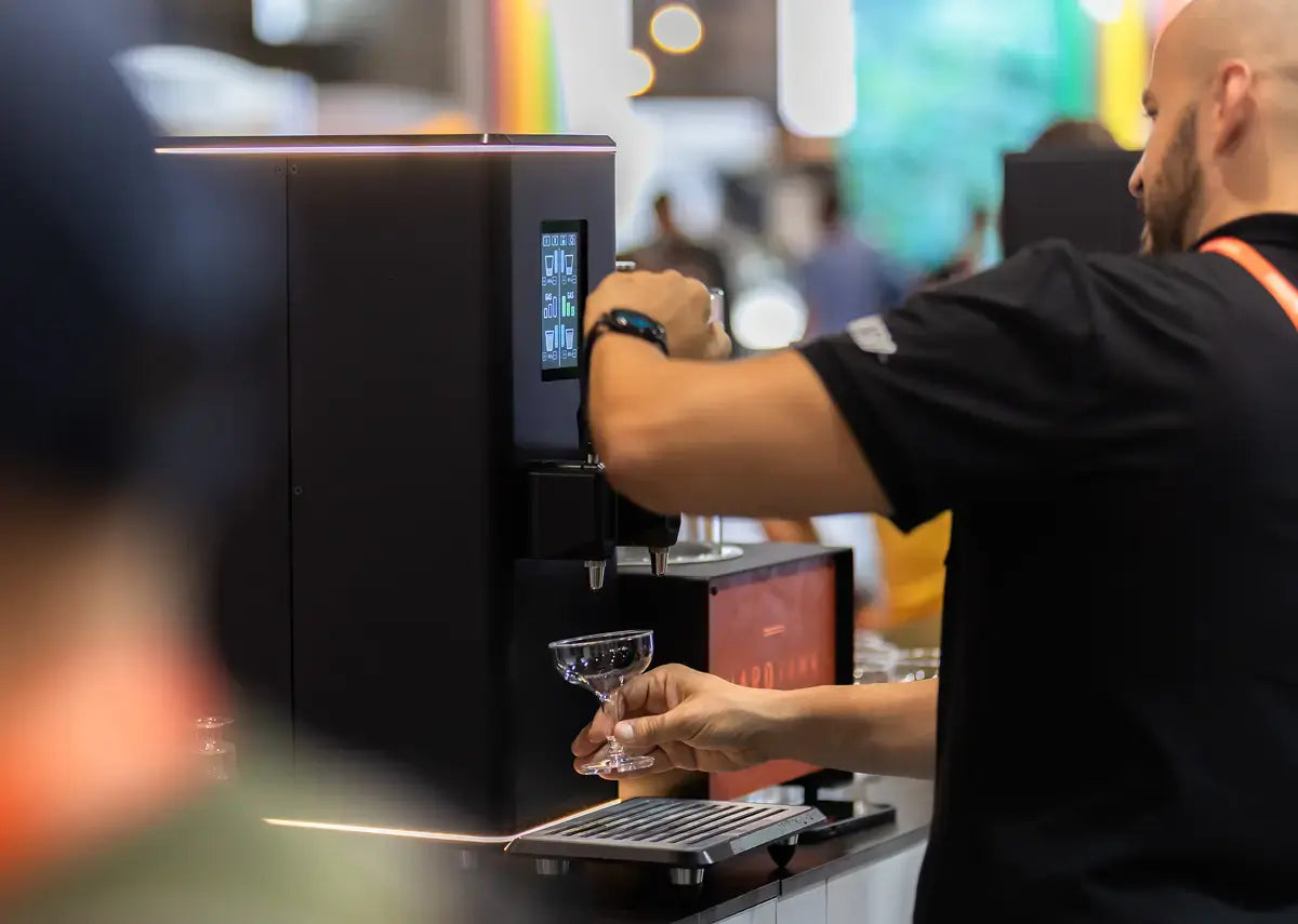 Barista pouring a drink from a Hardtap at World of Coffee Geneva